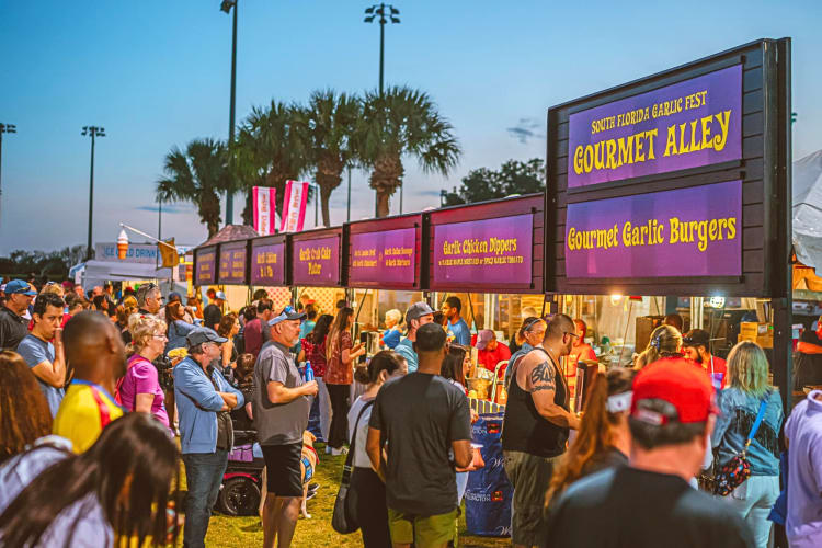 People waiting in line at the South Florida Garlic Fest to order food from vendors