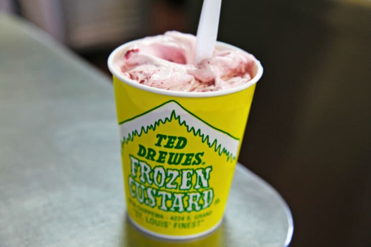 A yellow and green cup with strawberry ice cream