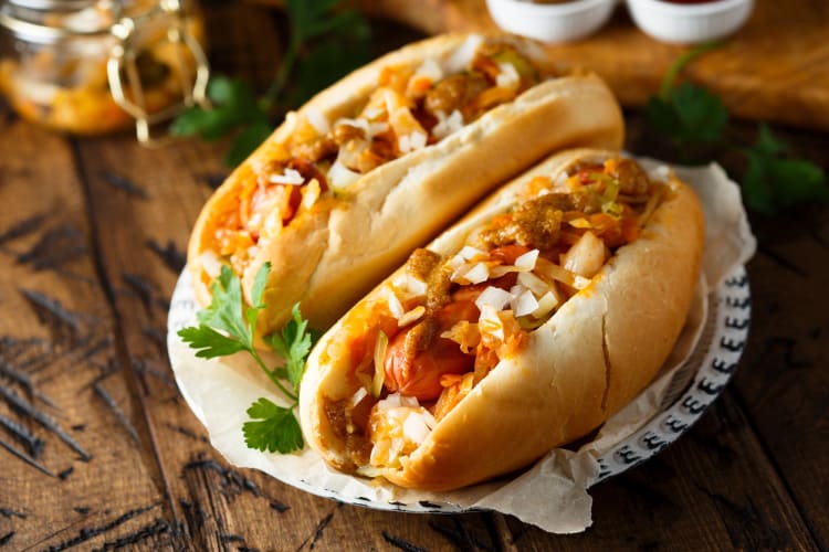 Hot dogs on a plate on a wooden table