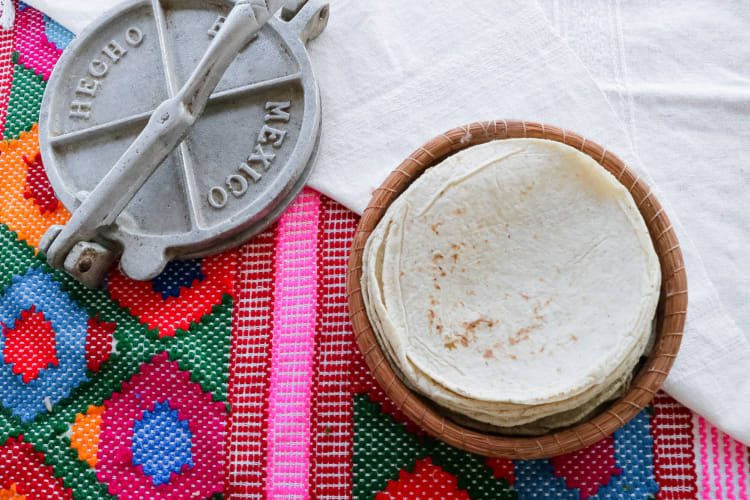 Stack of tortillas next to a lid with 