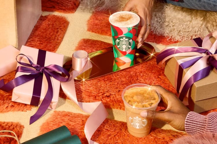 Gifts and Starbucks holiday drinks on a carpet