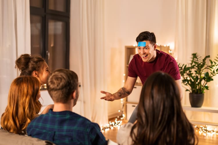 Friends playing a guessing game with sticky notes at home