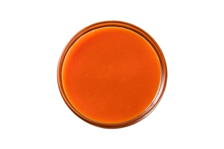 A small dish with hot sauce in it
