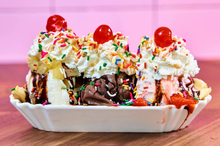 An ice cream sundae topped with whipped cream and cherries