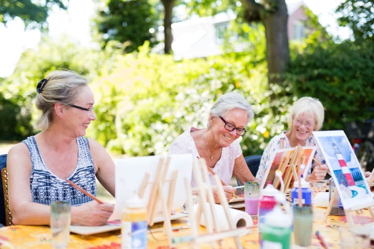 People painting at a table outdoors