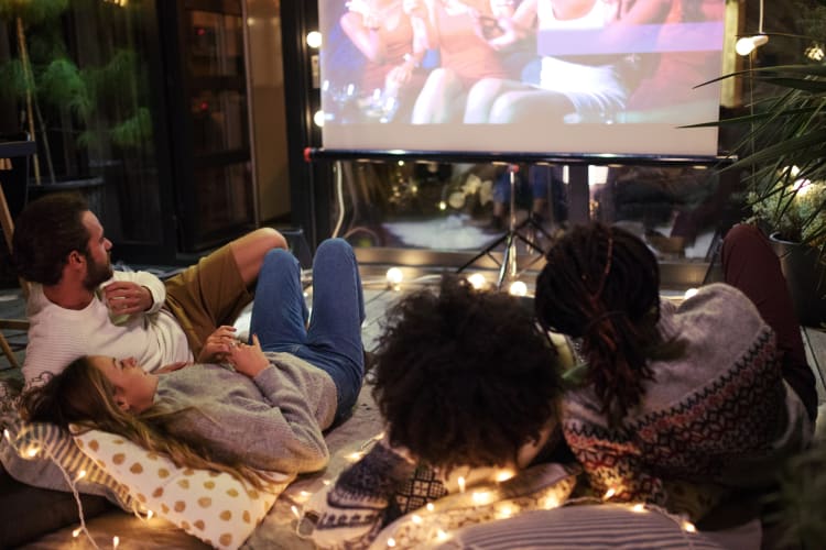 People watching a movie in the backyard