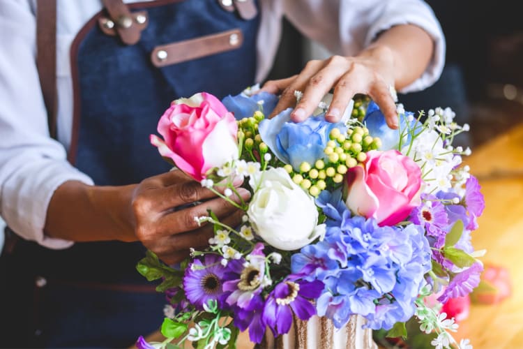 A person arranging a bouquet of flowers 
