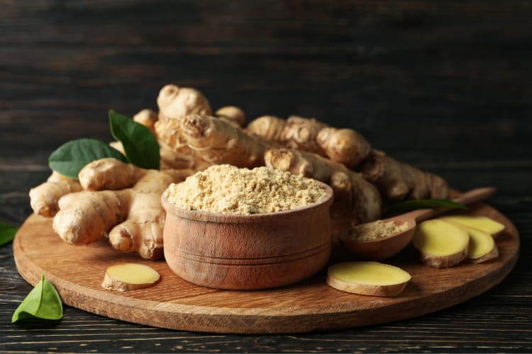 Fresh and ground ginger on a wooden board