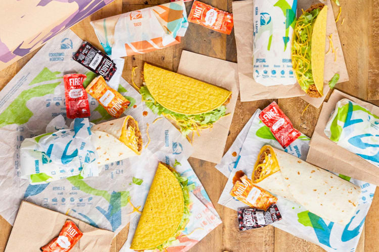 Tacos, burritos and various Taco Bell sauces on a table