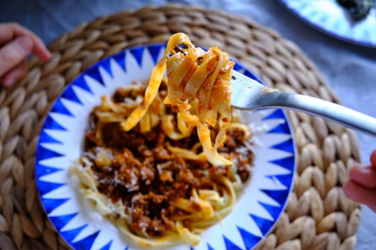 Close-Up shot of Tagliatelle al Ragù being eaten with a fork