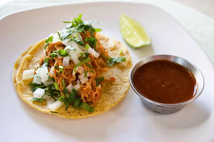 Taco with side sauce from Tamale Boy, a family-friendly restaurant in Portland