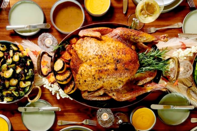A whole roast turkey and other Thanksgiving dishes on a table