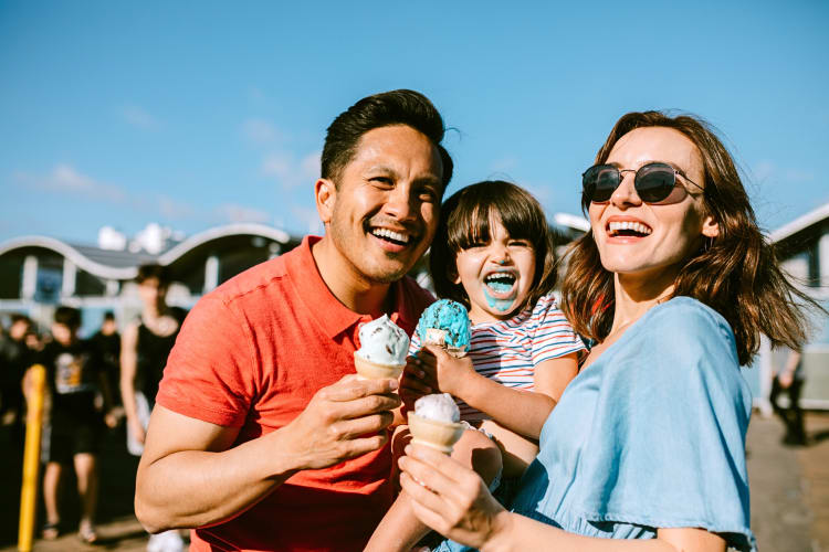 Mother, father and a child all eating ice cream outdoors