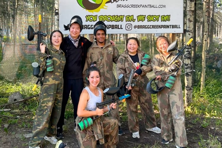 A group posing for a photo with paintball guns