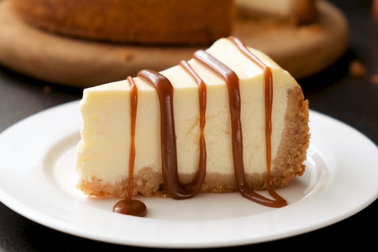 A slice of cheesecake with caramel sauce