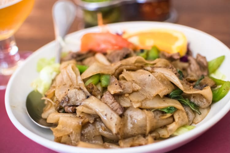 A plate with a beef and rice noodle dish