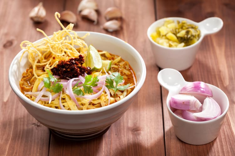 A bowl of soup with crispy noodles