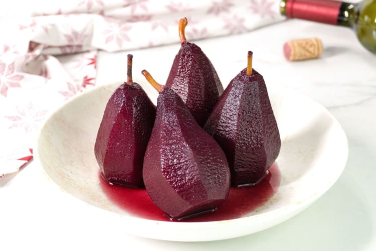 A bowl of pears poached in red wine.