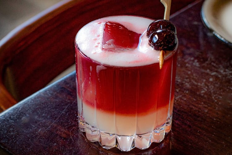 A cocktail topped with two cherries, from The Apparatus Room, a birthday restaurant in Detroit