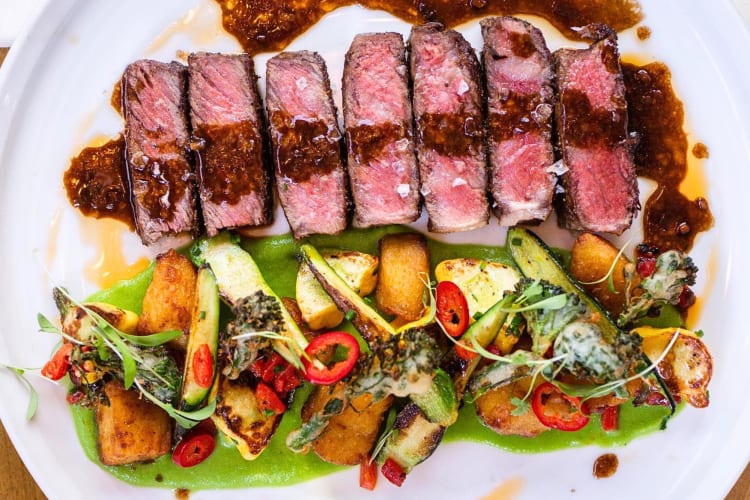 Aerial view of sliced pieces of steak with vegetables and potatoes, from The Lime Lite