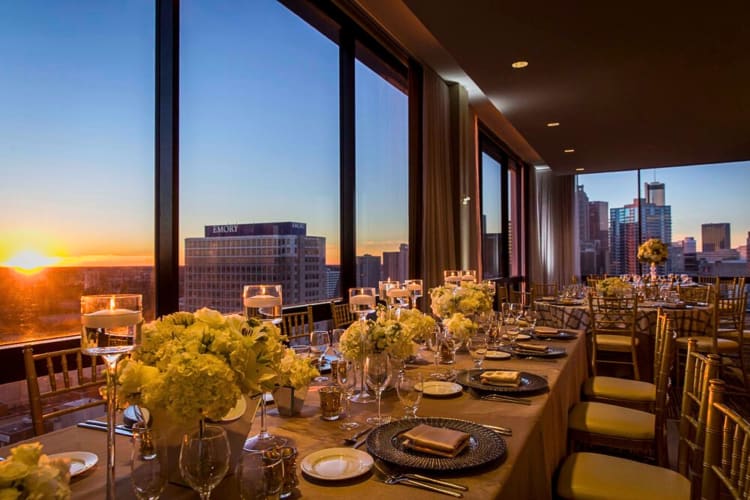 Tables at The SKY Room overlooking a skyline view through windows