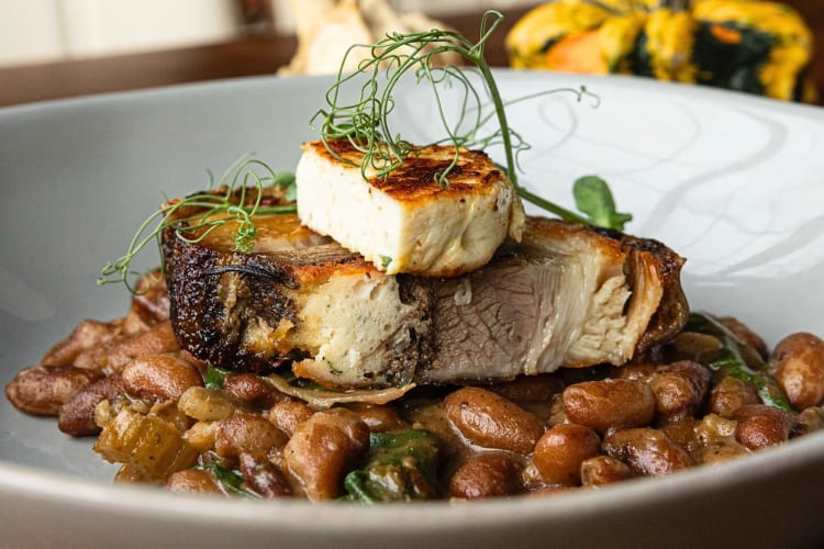 Close-up of a dish with meat on top of beans, from The Søvengård, a Grand Rapids restaurant