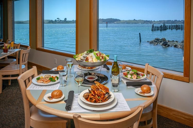 A table with five meals on at The Tides Wharf & Restaurant, overlooking the ocean