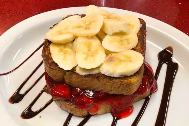 French toast with strawberry jam topped with banana slices