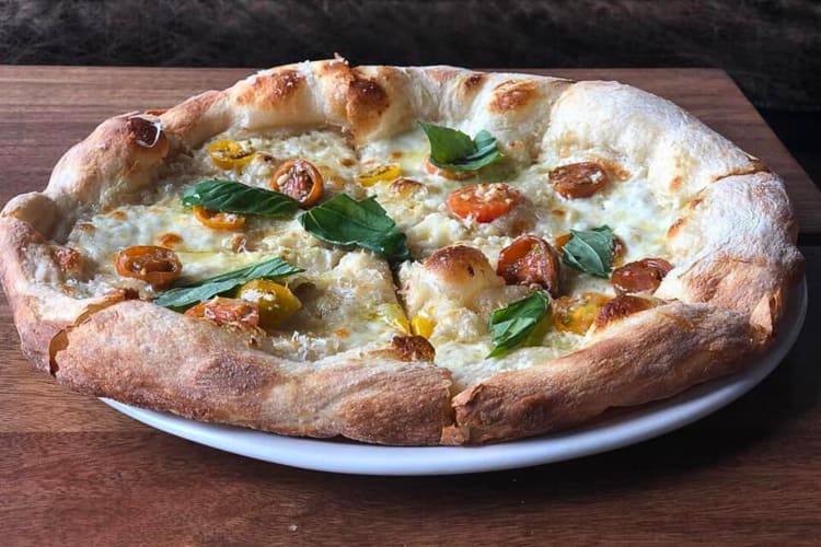 Pizza with tomatoes and leaves on from The Wylder in Boise