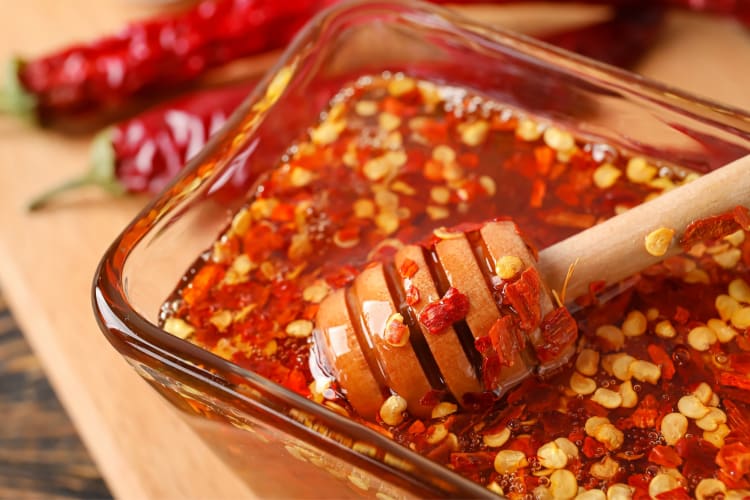 A honey dipper in a bowl of spicy honey