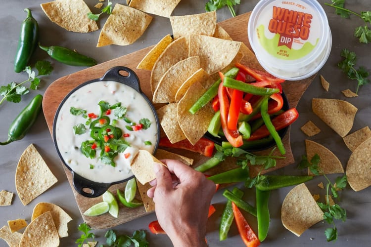 White queso dip with tortilla chips and raw bell peppers