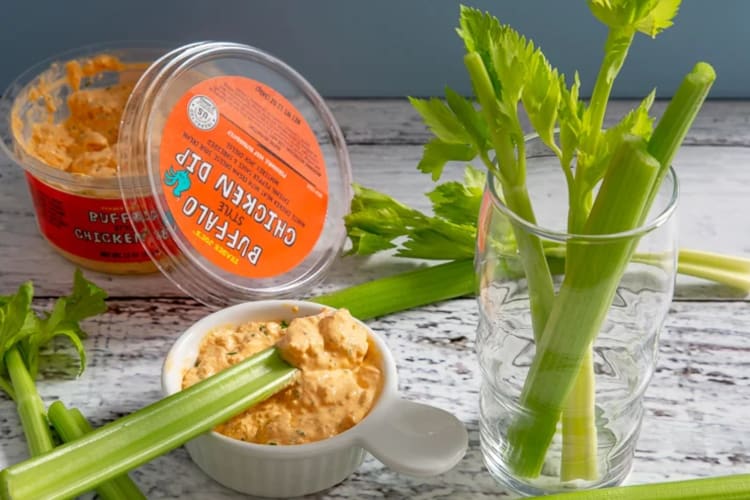 Celery sticks next to a tub of Buffalo chicken dip