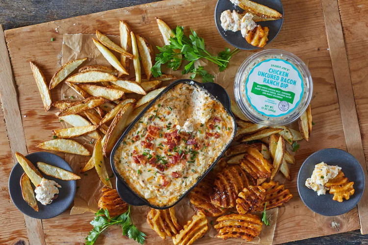 A cooked dip with potatoe wedges and waffle fries