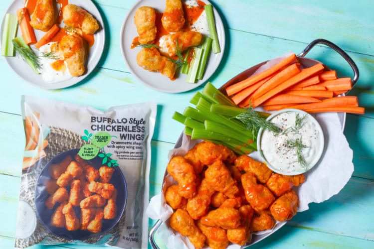 Plates of plant-based Buffalo chicken wings next to the packaging
