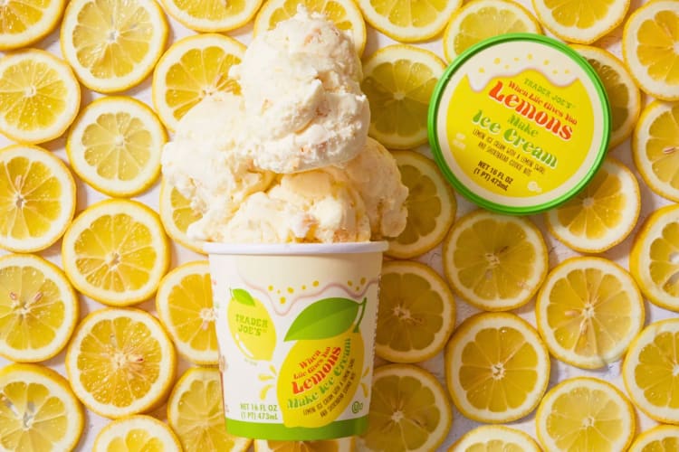 A tub on lemon ice cream on top of fresh lemon slices