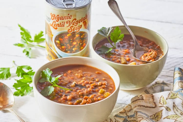 Bowls of soup next to a tin of lentil soup