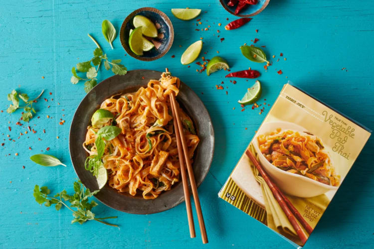 A box of vegetable pad thai next to the dish on a plate