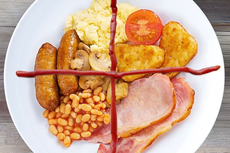 Aerial view of a breakfast with sausages, eggs, mushrooms, baked beans, hash browns and bacon