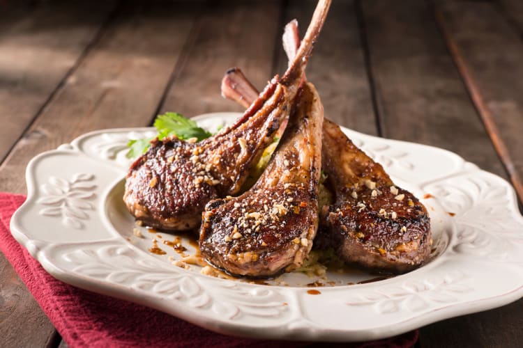 Three lamb chops on a white plate