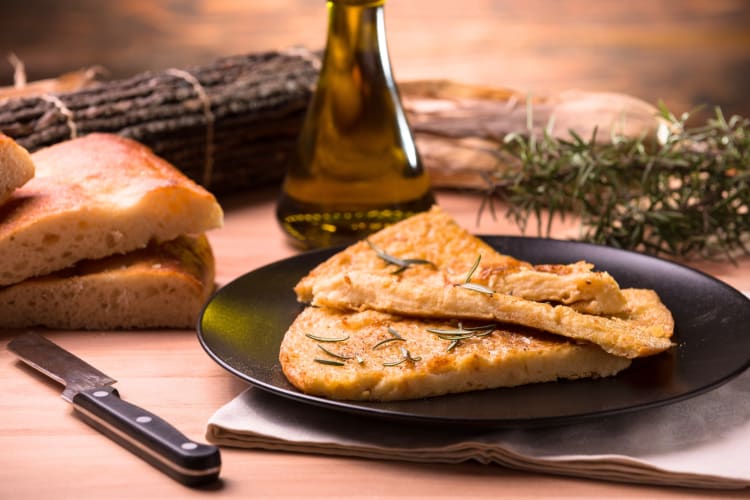 Slices of flat bread on a plate next to rosemary sprigs