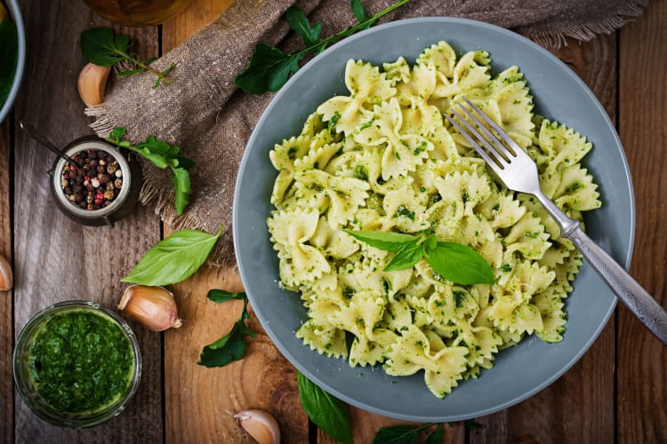 A bowl of bow tie pasta with green pesto