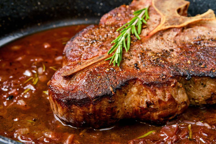 Close-up of a cooked steak with garnish on top