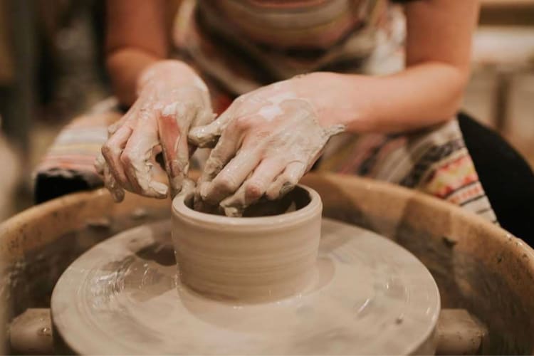 A person making ceramics on a pottery wheel