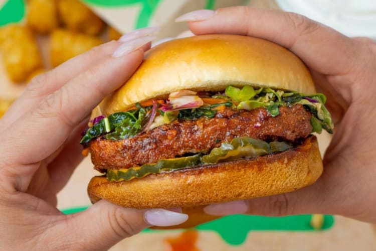 A person holding a veggie burger
