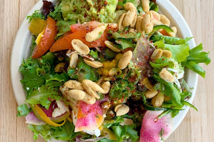 A salad with different vegetables and peanuts