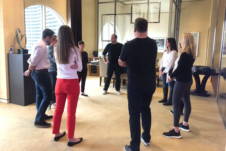 Nine people standing around and engaging in a company improv session