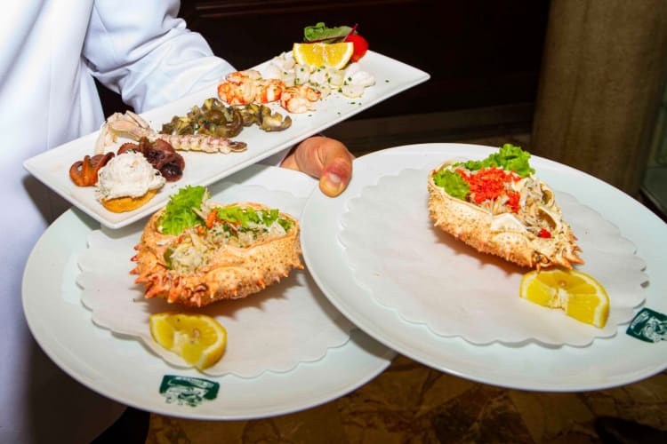 A selection of seafood dishes being carried by a waiter