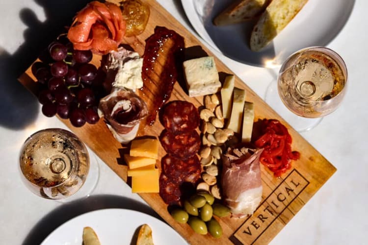 Aerial view of a charcuterie board in between two glasses of wine, from Vertical Detroit