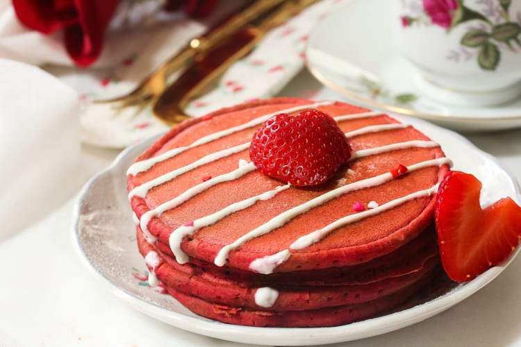 Red velvet pancakes topped with strawberries and cream
