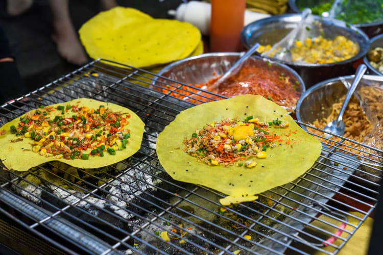 crispy vietnamese savoury pancakes cooking on a griddle